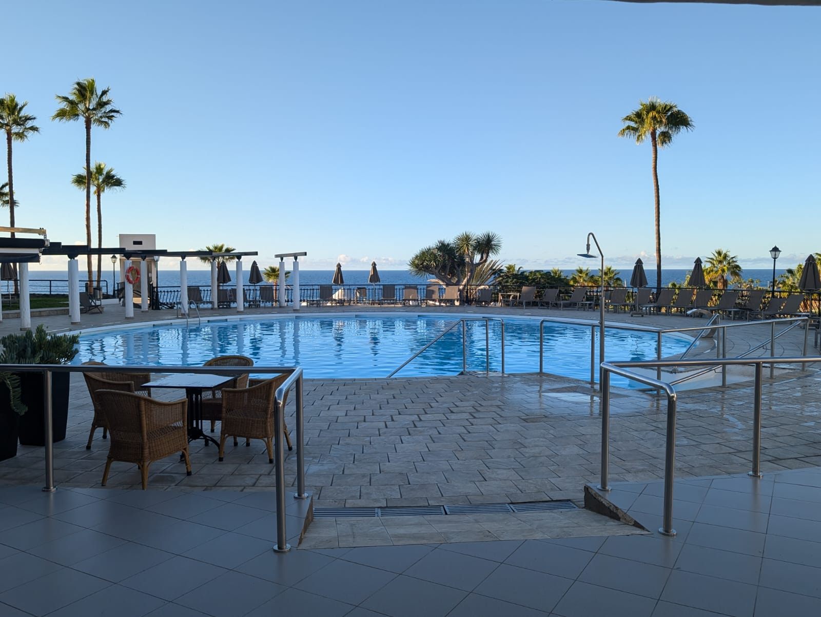 Poolterrasse der Anlage mit Palmen und Blick auf den Atlantik
