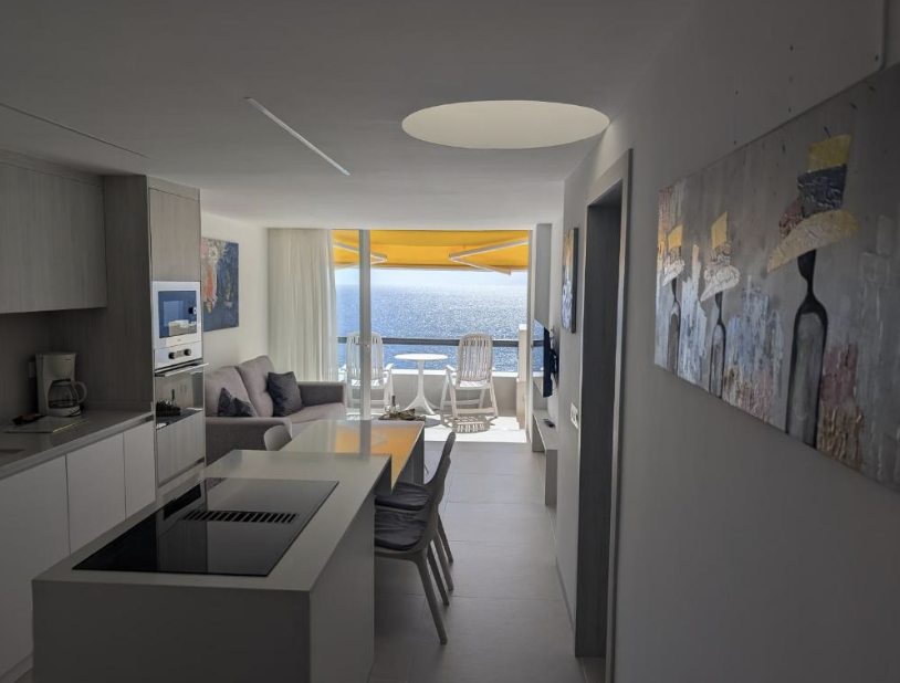 Offene Wohnküche mit moderner Einbauküche und Blick aufs Meer